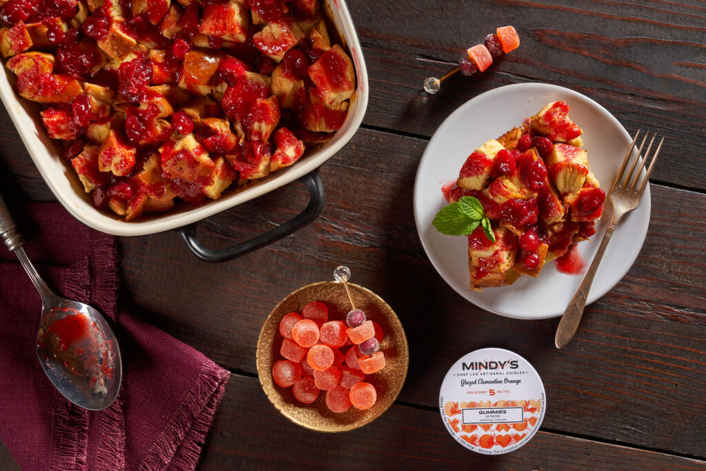 Bread pudding on a plate with glazed clementine orange gummies next to it